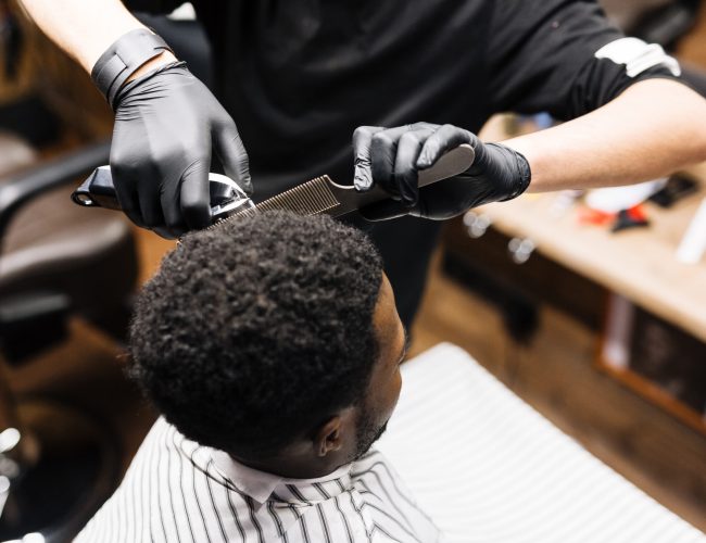 Stylist cutting hair of his client